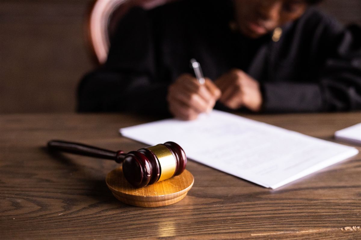 A judge signing a document beside a gavel
